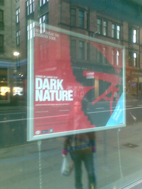 Dark Nature poster displayed in a shop window